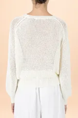 Sweater de punto color blanco con textura en relieve, cuello redondo y mangas largas abullonadas con puños ajustados.