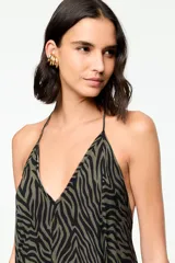 Vestido largo de corte fluido con escote en V, breteles finos, espalda descubierta y estampado animal print de cebra en tonos verde militar y negro.