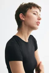 Remera entallada de microfibra en color negro, con cuello redondo fino y mangas cortas.