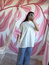 Remerón blanco de algodón con mangas cortas y tres tiras fucsias en cada hombro.