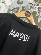 Remera negra con estampado de Saitama de One Punch Man haciendo el gesto de OK y otro dibujo de su cara.