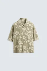 Camisa de manga corta y corte relajado confeccionada en tejido de algodón con diseño jacquard floral. Presenta cuello bowling, un bolsillo de plastrón en el pecho y cierre frontal con botones.