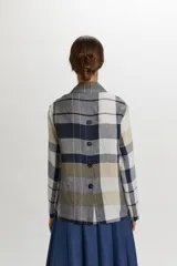 Blazer cruzado de lino con estampa a cuadros en tonos azul marino, blanco, beige y verde militar. Cuenta con solapas de muesca, doble botonadura frontal y bolsillos con solapa en los laterales.