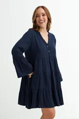 Vestido corto azul marino con escote en V, cierre parcial de botones, mangas 3/4 acampanadas y falda con volados escalonados.