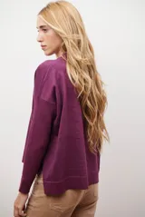 Buzo de punto color beige, con cuello redondo y manga larga.