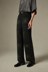 Pantalón de jean negro de corte ancho y tiro alto, decorado con aplicaciones de strass formando estrellas en toda la superficie.