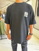 Remera oversize blanca con gran estampado en la espalda de diseño floral simétrico en tono oscuro. Cuenta con mangas cortas y calce holgado.
