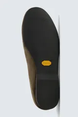 Zapato tipo mocasín sin cordones fabricado en piel con acabado serraje. Presenta talón plegable, horma redonda y suela de goma Vibram.