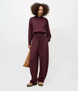 Pantalón de corte barrel con diseño de piernas anchas y cintura cónica. Confeccionado en tejido de modal con elástico en la cintura y lazo ajustable. Presenta un acabado liso y fluido.