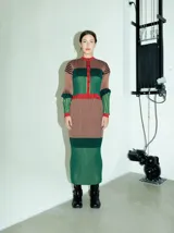 Pollera midi de punto acanalado con diseño multicolor a rayas verticales en tonos verde, marrón y rojo. Presenta un corte ajustado tipo lápiz y cintura elástica de tiro alto.