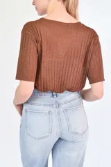 Remera de punto acanalado en color verde, con cuello polo y mangas cortas.