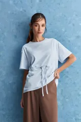 Remera celeste de algodón con cuello redondo, mangas cortas y cordón ajustable en la cintura.