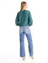 Blusa de satén color verde petróleo, con escote en V y cuello decorado con mostacillas bordadas. Presenta mangas largas con puños elásticos y ruedo también elastizado, brindando un ajuste cómodo y holgado.