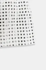 Minifalda blanca con lentejuelas negras formando un patrón geométrico.