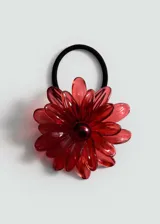 Accesorio para el pelo con forma de flor roja de acrílico y goma elástica negra.
