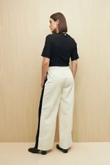 Pantalón de corte recto color negro con franjas laterales blancas a contratono. Cuenta con cintura elástica, cordones de ajuste y bolsillos laterales.