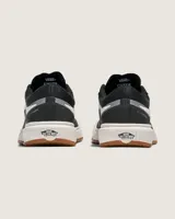 Championes Vans modelo Ultrarange 2.0, color negro con detalles en blanco y suela de goma color caramelo. Presentan diseño moderno con entresuela amortiguada, sistema de cordones y estructura reforzada en el talón.