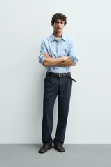 Pantalón de corte recto confeccionado en tejido elástico, con cintura elástica, pliegues frontales, bolsillos laterales y bolsillos traseros de vivo con botón.