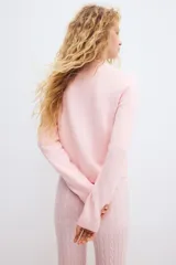 Saco entallado de punto fino, color rosado, con cuello redondo, cierre frontal de botones y terminaciones acanaladas en cuello, puños y ruedo.