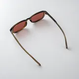 Lentes de sol Icon modelo Merlot, con armazón rectangular translúcido en tono marrón y cristales oscuros.