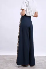 Pantalón palazzo azul marino con apliques bordados de hojas en los laterales.