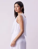 Vestido largo blanco de crepe con escote redondo y detalle de crochet en los hombros. Tiene corte en la cintura con punto smock.