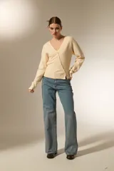 Saco de punto con cuello en V y cierre frontal con botones. Presenta un diseño ajustado al cuerpo, manga larga y terminación acanalada en el ruedo.