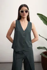 Chaleco de lino color verde oscuro, con escote en V, cierre frontal con botones y corte recto.