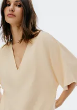 Blusa negra de manga corta, con escote pronunciado en V y corte holgado.