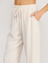 Pantalón holgado de lino color beige de la marca Allie Rose, con tiro alto y pretina elastizada con cordón de ajuste.