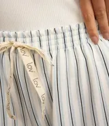 Conjunto de pijama short doll compuesto por musculosa blanca de ribana y short rayado con lazo en la cintura.
