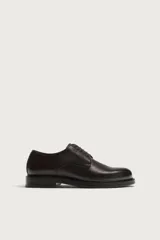 Zapato de cordones tipo blucher color marrón oscuro, confeccionado en piel con horma redonda y suela con ligero tacón.
