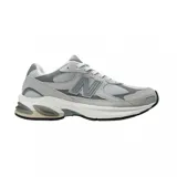 Championes New Balance modelo Abzorb 2010, color gris con detalles en blanco y plateado. Diseño urbano con paneles de malla y gamuza, entresuela con tecnología de amortiguación y logo N característico en los laterales.