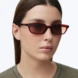 Lentes de sol con armazón rectangular alargado de color bordó y cristales polarizados en tono marrón.