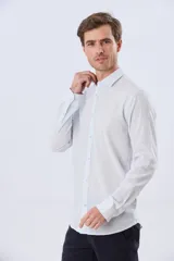 Camisa de lino a rayas finas en tonos beige y blanco, de manga larga con puños vueltos, cuello camisero y cierre frontal de botones. Cuenta con un pequeño logo bordado en el pecho.
