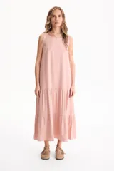 Vestido largo negro de lino, sin mangas, con escote redondo y diseño fluido con volados escalonados en la falda.