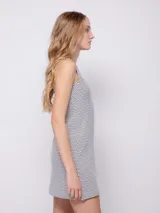 Vestido corto sin mangas de tela texturada con tirantes anchos y estampado a cuadros en blanco y negro.