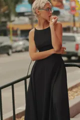 Vestido midi de gabardina en color negro, con cuello halter, tirantes finos y falda con vuelo. Cuenta con cierre en la espalda con cremallera oculta.