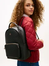 Mochila negra de poliuretano con textura y monogramas TH en bajo relieve, cierre de cremallera superior, bolsillo frontal con cierre, asas ajustables y detalles metálicos dorados.