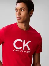 Remera Calvin Klein de color rojo, con cuello redondo, mangas cortas y corte regular. Presenta el logotipo y monograma de la marca impresos en gran tamaño en el centro del pecho.