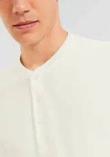 Camiseta azul con cuello henley y tapeta de tres botones.