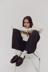 Zapatos náuticos de cuero color marrón con cordones frontales, ojales metálicos dorados y costura de mocasín en la puntera.