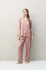 Camisa de pijama color verde menta, de silueta clásica y tacto sedoso. Confeccionada en tejido satinado con leve elasticidad, presenta cuello camisero, cierre frontal con botones y detalles de vivo blanco que realzan el diseño.