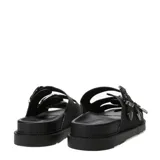 Sandalias de mujer Miss Carol Valencia, de color negro con tres tiras anchas en el empeine, cada una con hebillas metálicas plateadas de diseño occidental y punteras grabadas. Presentan suela plana con plataforma ligera y plantilla acolchada.
