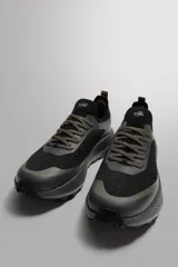 Zapatilla deportiva Zara Athleticz de color negro, diseñada para correr y uso diario. Cuenta con parte superior de tejido de punto transpirable, refuerzos en puntera y talón con tecnología Shield Protect Max, entresuela Spume Foam V3 y cordones en tonos tierra.