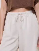 Bermuda holgada de pierna recta, confeccionada en mezcla de algodón, poliéster y lino. Presenta pretina fruncida con elástico interno, cordón ajustable en la cintura y bolsillos laterales.