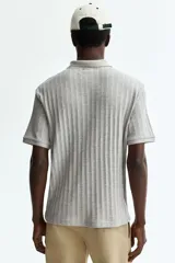 Remera polo de punto texturizado H&M, color gris, de manga corta, con cuello, tapeta con botones y corte ajustado.