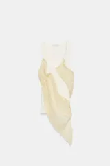 Top de cuello redondo y sin mangas, confeccionado en tejido de punto acanalado color crema. Presenta una aplicación asimétrica de tela tipo georgette en tono beige claro que cruza el frente de la prenda.