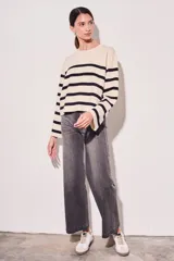 Sweater de punto con diseño a rayas horizontales en color crema y marrón, de corte holgado, cuello redondo y mangas largas acampanadas.