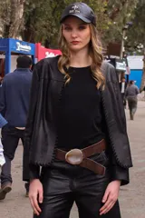 Campera de cuero negro con detalles de costuras decorativas en los bordes delanteros y mangas largas.